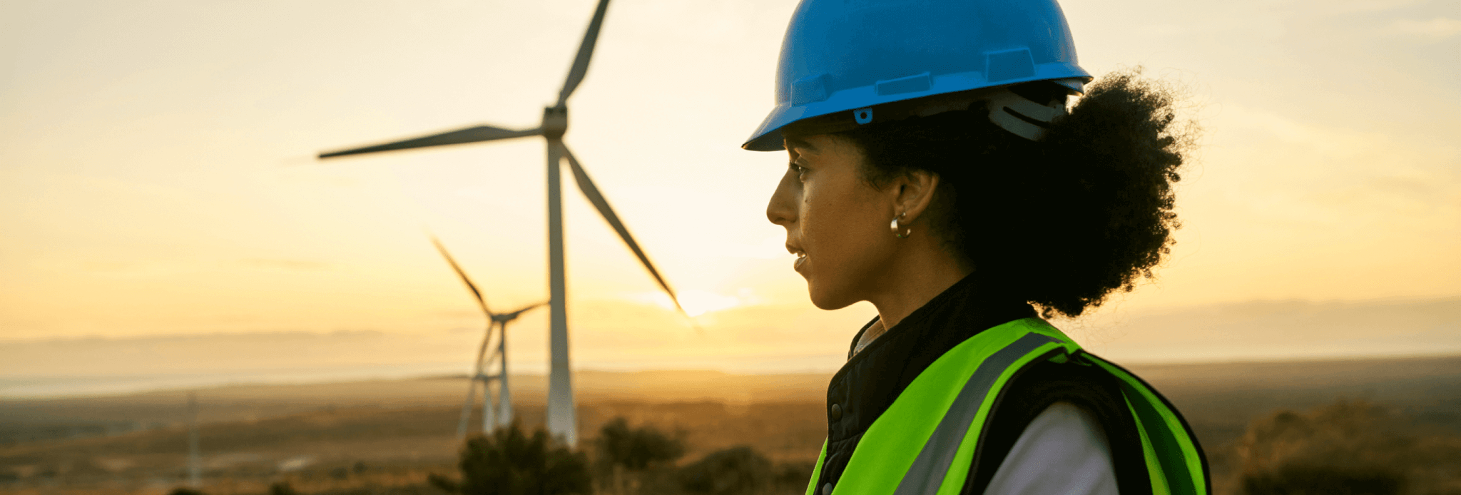 An engineer standing in a wind energy farm