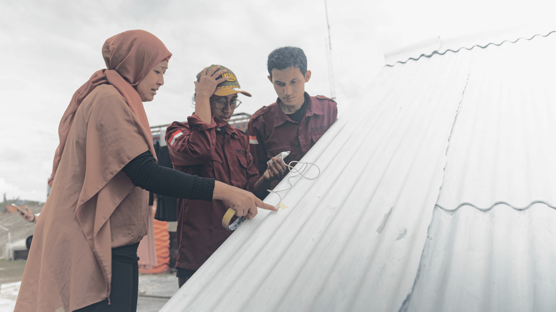 Three people working on a roof
